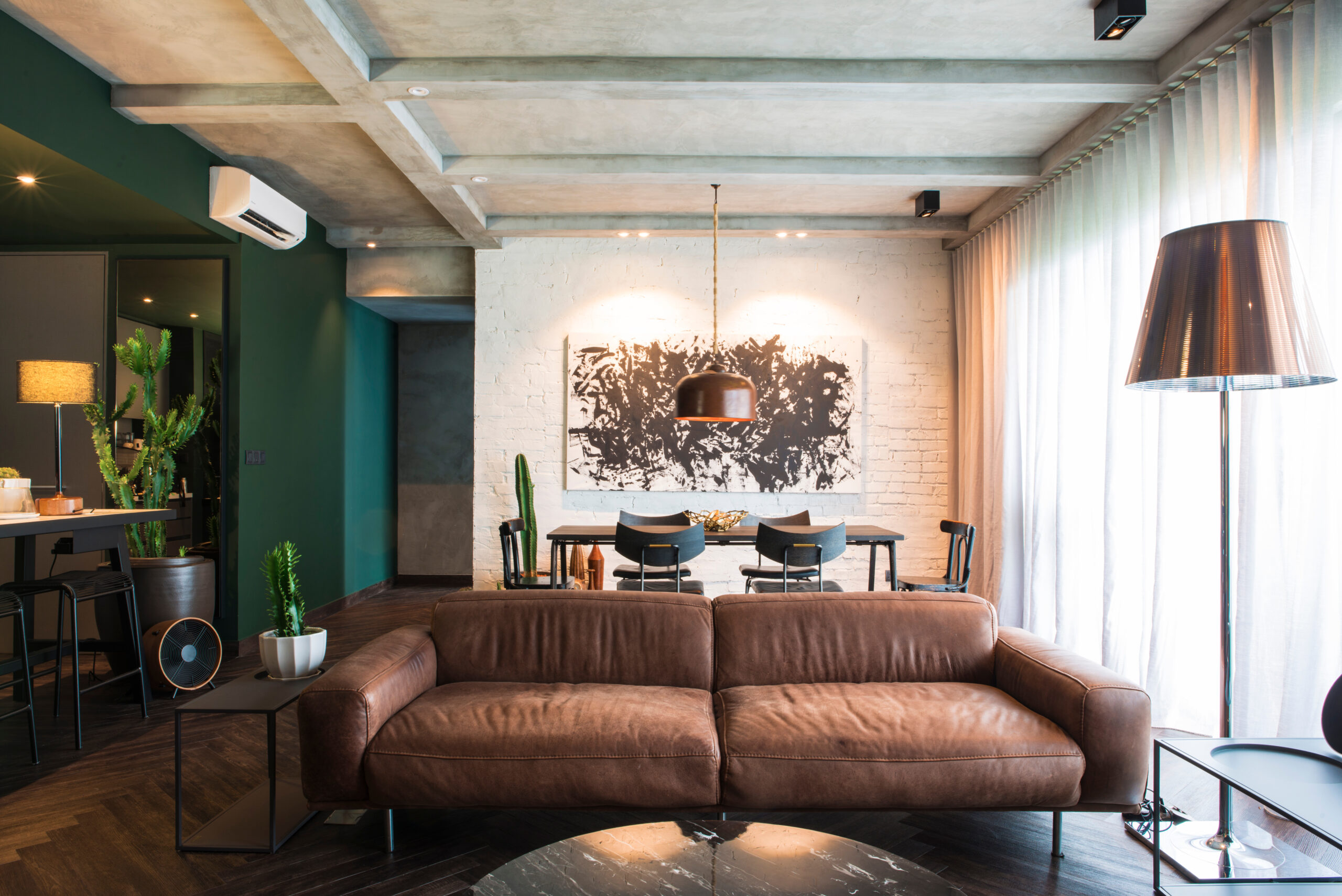 Loft urbain aux poutres de béton et mur de brique blanchie