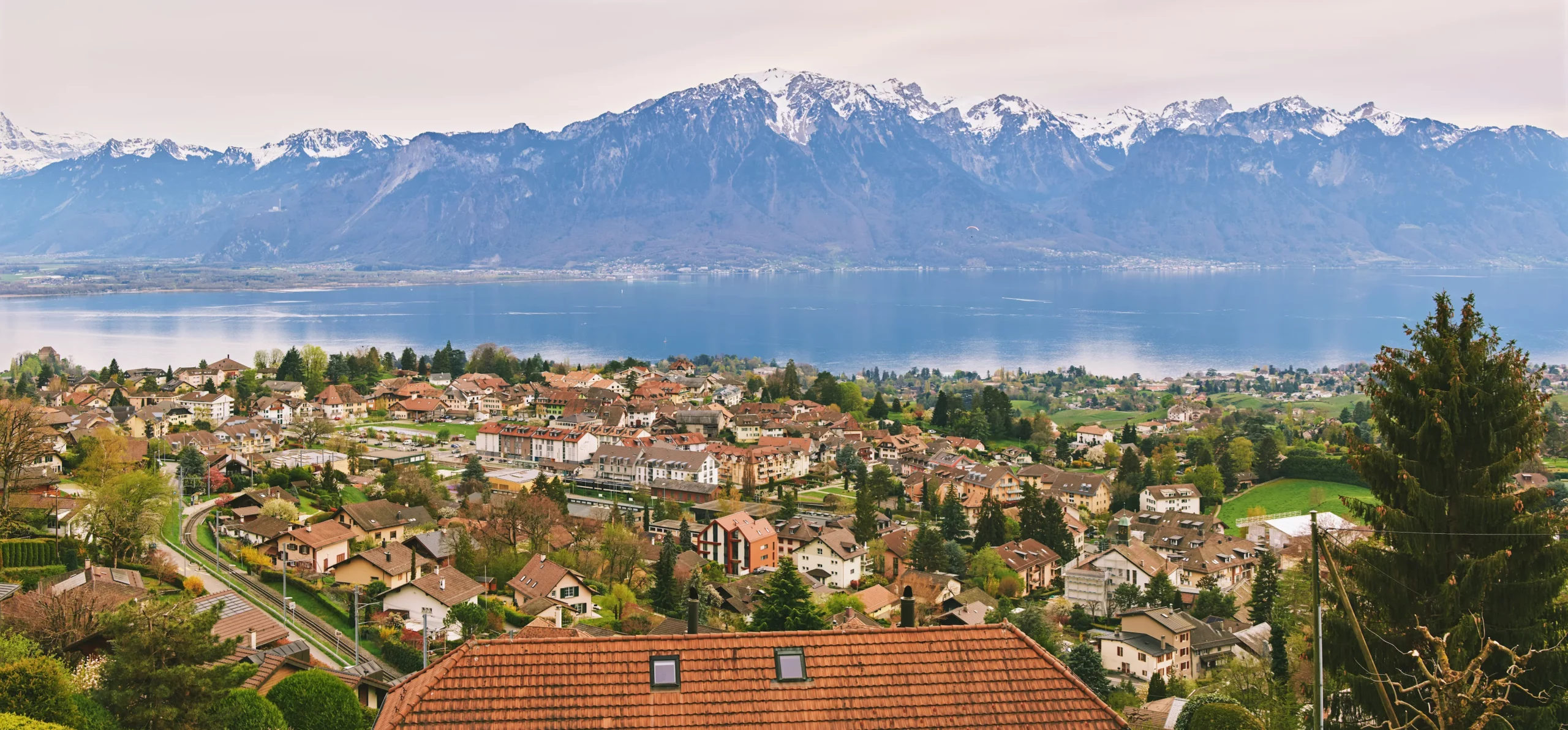 Village vaudois surplombant le Léman, face aux Alpes enneigées